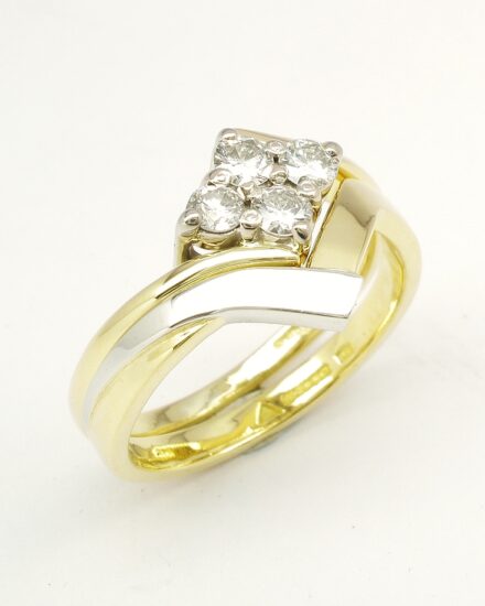 An 18ct. yellow gold and platinum shaped to fit around a 4 stone round brilliant cut diamond cross-over ring.